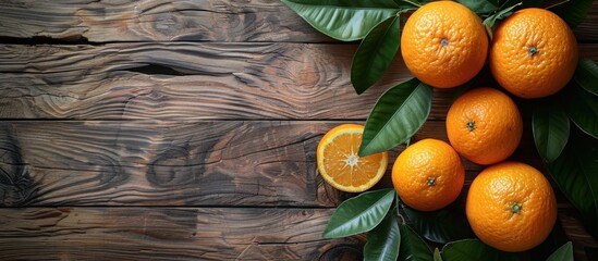 Wall Mural - Oranges and Leaves on Rustic Wooden Background