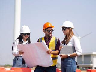 A group of engineers and architects are consulting. About taking care of wind turbines For a sustainable environment