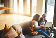 © ClearConcept/peopleimages.com - Laptop, family and kid with parents in home together for learning, education or teaching child typing. Girl, mother and father on computer to watch movie, cartoon and relax on sofa in living room
