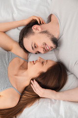 Poster - Family portrait of lovely couple on bed at home, top view