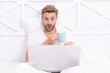 © be free - Man lying in bed and surfing internet on laptop. Work from home online on laptop. Weekend workaholic. Morning coffee online. Freelancer in bed. Millennial man work on laptop at home. Video call