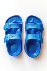 Poster - A pair of blue sandals lying on a white background, suitable for still life photography or fashion branding