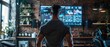 © NDmCX-Nic - Man standing in front of a large screen in a dimly lit room.