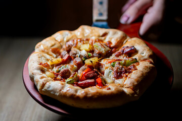 Freshly baked pizza on a wooden paddle