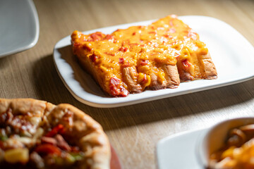 Wall Mural - Cheesy bread sticks with melted cheese and tomatoes