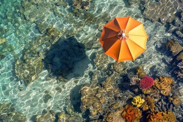 Canvas Print - Aerial view of a vibrant beach umbrella casting a shadow on the clear, shallow sea, with colorful coral reefs visible beneath the crystal-clear water.