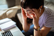 © Marko Geber - Close up of a stressed Asian woman working at home