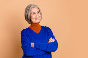 Sticker - Photo portrait of lovely pensioner lady look empty space crossed hands dressed stylish blue garment isolated on beige color background