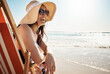 © Reese Coop/peopleimages.com - Girl, laugh and sunglasses at beach with water, sand and relax for vacation by ocean in summer. Female person, smile and sun hat on chair in Miami for tropical holiday, travel or peace with wellness