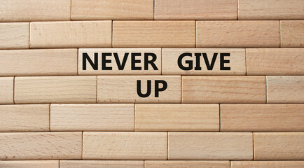 Wall Mural - Never give up symbol. Concept words Never give up on wooden blocks. Beautiful wooden background. Business and Never give up concept. Copy space.