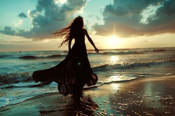 Wall Mural - A woman strolling along the shoreline as the sun sets over the ocean