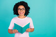 © deagreez - Photo portrait of lovely young lady look empty space read book dressed stylish striped garment isolated on aquamarine color background