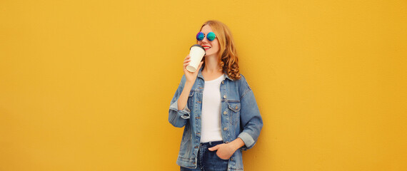 Wall Mural - Modern stylish happy young woman drinking coffee posing on bright yellow background
