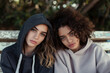 © ArtCraft - Pensive young lesbian couple in hoodies. A contemplative scene depicting friendship, love, and connection. Ideal for lifestyle, diversity campaigns, and emotional narrative.