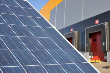 Element of a solar power plant against the background of a modern logistics center.