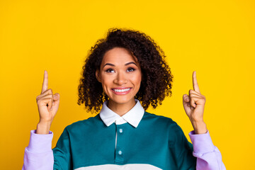 Wall Mural - Photo of adorable woman with curly hair dressed striped top directing look at sale empty space isolated on yellow color background