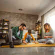 © Miljan Živković - Dad, mum and son play dominoes together on the floor at living room