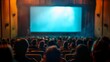 © Pornarun - An audience awaits the start of a film in a dark movie theater.  The screen is lit, anticipating the show.
