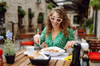 © maxbelchenko - Portrait of a smiling woman eating pasta  at cozy italian restaurant outdoors. Concept of italian cuisine and lifestyle. Travel, tourism, food and drink.