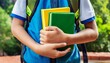 © Rmcarvalhobsb - Um jovem estudante de mochila segurando dois livros. Livros nas cores verde e amarelo. Referência as cores da bandeira do Brasil. Ensino médio, Educação, Brasileiro.