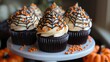 © Elena - Halloween party concept: chocolate muffins with orange cream and spider web. cute horrors. festive design.