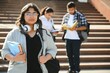 © Serhii - Three international students standing and holding a books