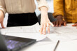 © DC Studio - Professional clients and their real estate agent engage in an office planning session, reviewing blueprints and discussing investment opportunity for urban workspace leasing. Close up.