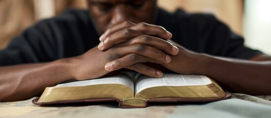 Person reading book praying with Bible. A man praying in front of Bible. Reading bible. Holy Bible. Christianity concept. Talking to God.