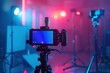 © Анатолий Сав - A video camera on a tripod is ready to record a streaming session. The camera is positioned in a studio setting with colorful lighting. Generative AI