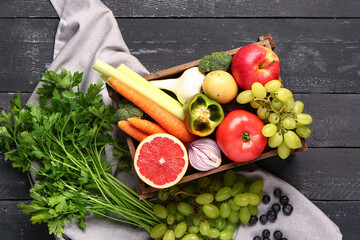 Wall Mural - Box with different fresh fruits and vegetables on black wooden background