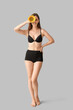 © Pixel-Shot - Young happy woman in underwear with beautiful sunflower on grey background