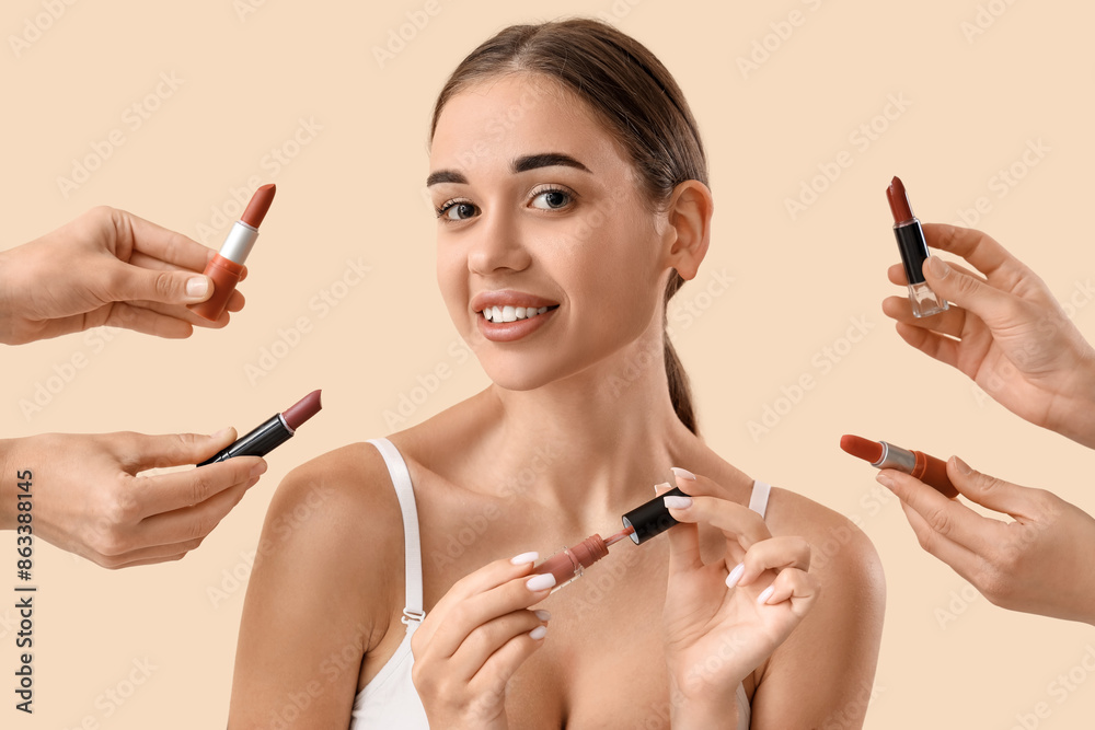 Young woman with lipsticks on light background