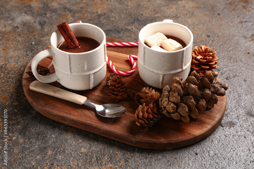 Cups of hot chocolate with marshmallows and cinnamon on dark background