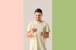 © Pixel-Shot - Young man using tablet computer on color background. Online dating concept