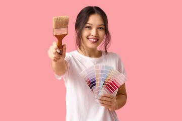 Wall Mural - beautiful young woman with paint brush and palette samples on pink background