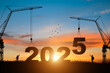 © Tarokmew - Silhouette of construction camp site with cranes building construction prepare to welcome the new year 2025 at sunset.