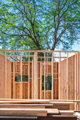 Wall Mural - New home construction in residential neighborhood, first floor of structural framing in progress on a sunny summer day
