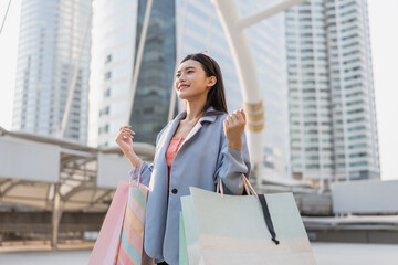 Asian beautiful woman buyer shopping goods outdoors in modern city. 