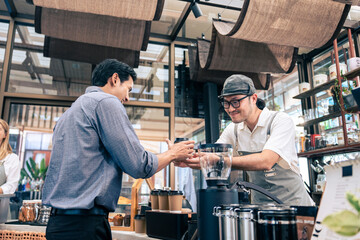 Asian attractive men receive hot coffee from waiter in coffee house. 