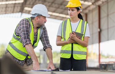 Wall Mural - Site manager and builder inspect the construction site, Female foreman worker and engineer team meeting for planning project at the precast concrete factory site