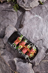 Wall Mural - Gourmet Roast Beef Roll Appetizer with Daikon and Cucumber on Stone Background