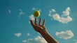 © kamonrat - A close-up shot of a woman's hand tossing a tennis ball in the air, perfectly positioned for a forehand swing