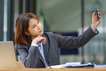 Young Asian businesswoman taking a selfie face at the office.