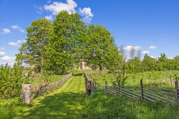 Canvas Print - Footpath with a picket fence to an old church