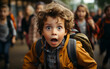 © imagineRbc - Photo of a young boy in a yellow jacket and backpack on his first day of school, eyes wide with excitement, looking directly at the camera