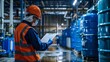 © ckybe - A laborer is reviewing the dangerous substance data sheet in the vicinity of the chemical storage facility at the manufacturing site, taking safety precautions.