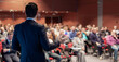 © kasto - Speaker giving a talk on corporate business conference. Unrecognizable people in audience at conference hall. Business and Entrepreneurship event.