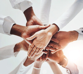 Wall Mural - Below, hands stack and medical people in hospital for healthcare support, solidarity and teamwork of workforce motivation. Staff, diversity and collaboration, trust and synergy together of clinic