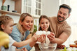 © Valerii Apetroaiei - Happy Family Cooking Together in the Kitchen with Children, Laughing, and Bonding