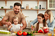 © Valerii Apetroaiei - The family is joyfully cooking together in a welllit kitchen using fresh ingredients